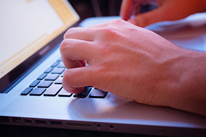 hands typing on laptop